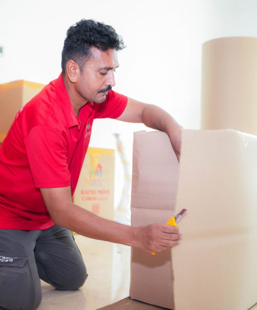 Rapid Move packer cutting cardboard to build a custom crate