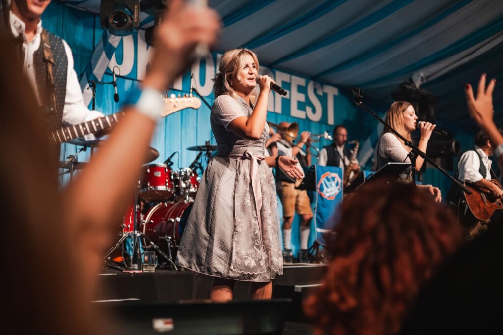 Singer in a dirndl performing with a live Oktoberfest band on stage at Grand Hyatt Dubai