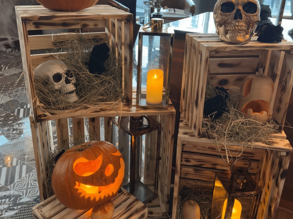 Glowing jack-o-lantern, skulls and candles in wooden crates at FireLake Grill House Halloween brunch