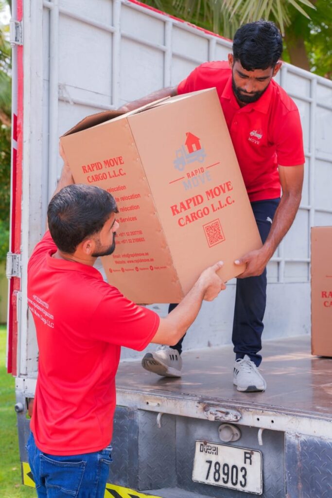 Rapid Move crew loading a packed box onto a moving truck in Dubai