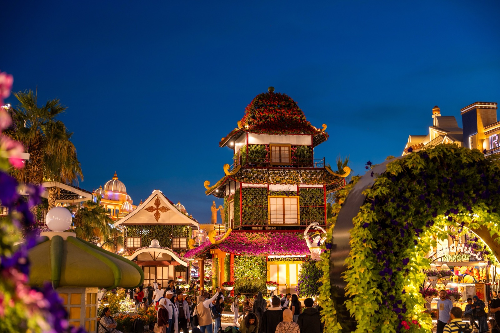 Flower-covered pagoda and arches at Global Village Dubai at night