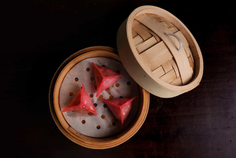 Pinktober Dubai special: three spicy pink duck gyoza in a bamboo steamer at Mott 32 Dubai