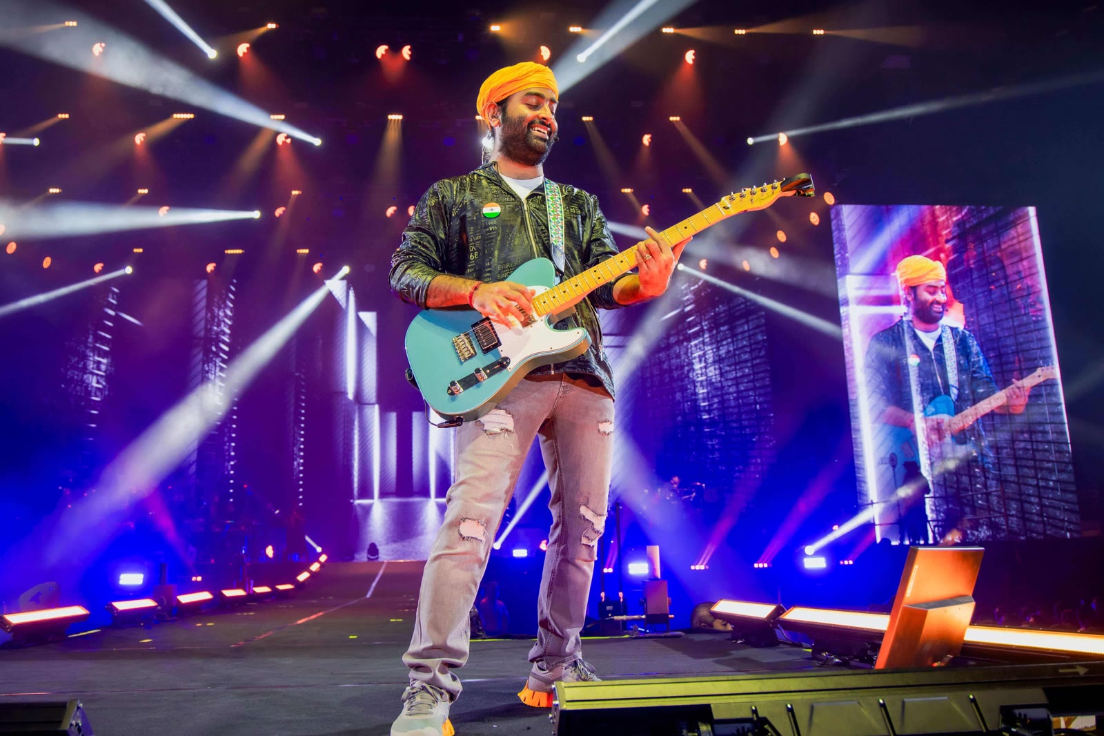 Arijit Singh singing on stage with a guitar, headliner at UNIFYD Festival Abu Dhabi