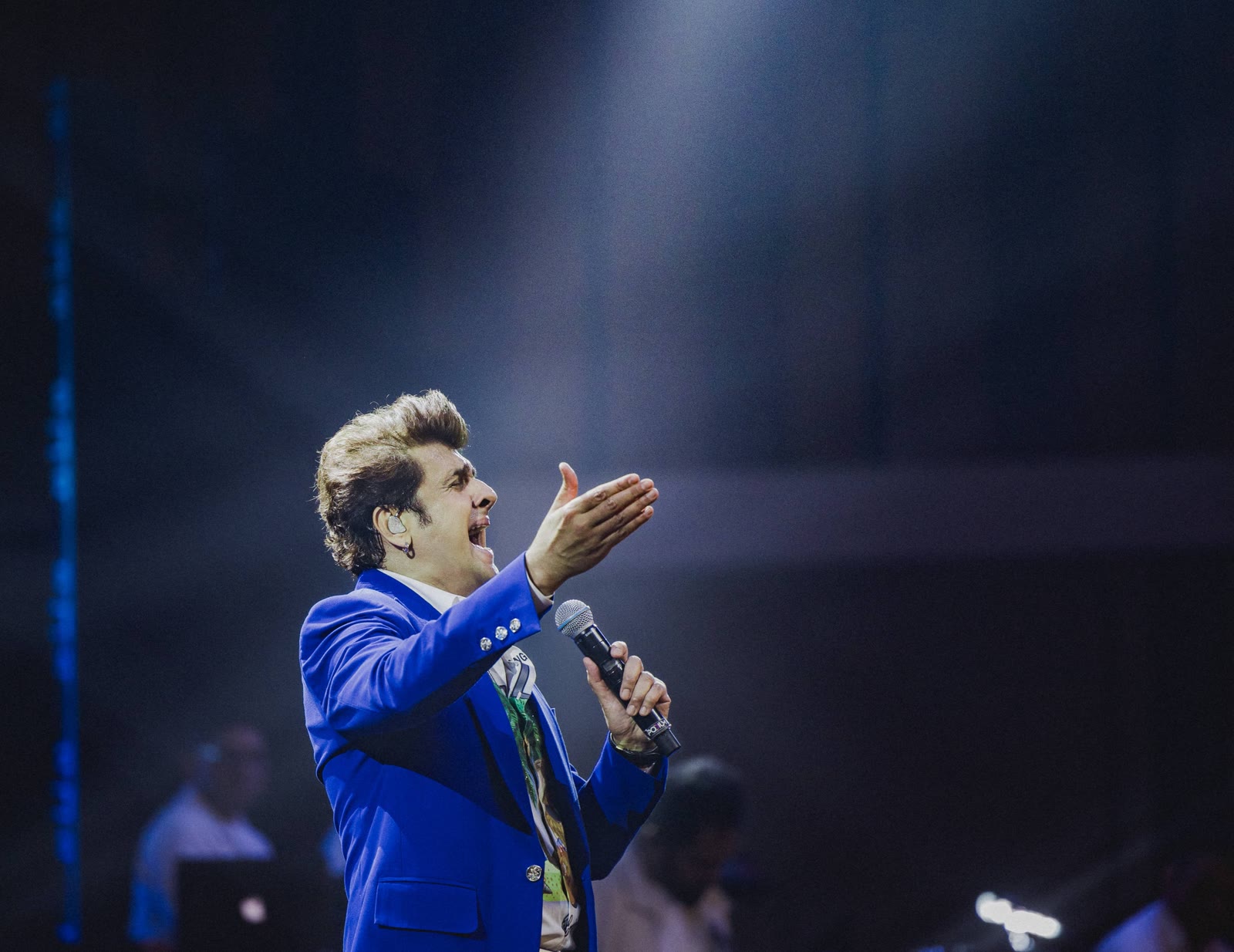 Sonu Nigam in a blue jacket singing on stage, headliner at UNIFYD Festival Abu Dhabi
